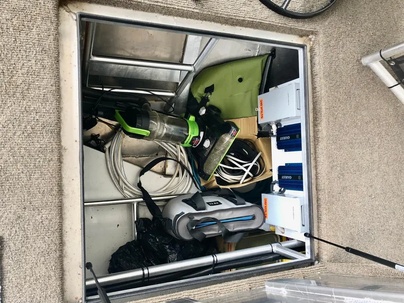 Slide: The Image of Storage compartment of a 2016 Thoroughbred 67x17 boat with cleaning supplies and equipment. - 19