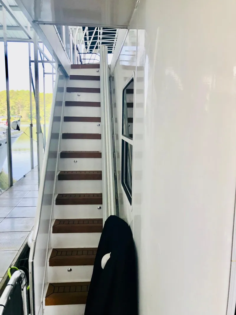 Slide: The Image of Staircase on a 2016 Thoroughbred 67x17 houseboat leading to the upper deck. - 22