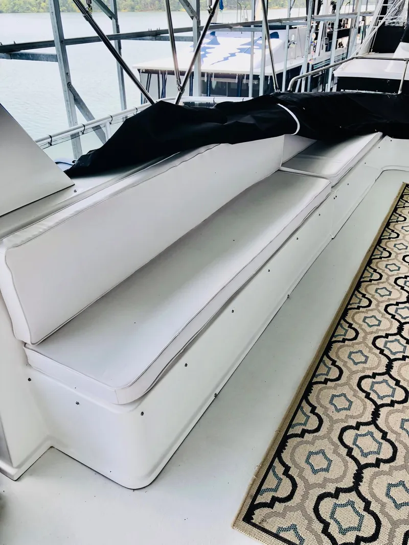 Slide: The Image of White seating area on a 2016 Thoroughbred 67x17 houseboat with patterned rug. - 25