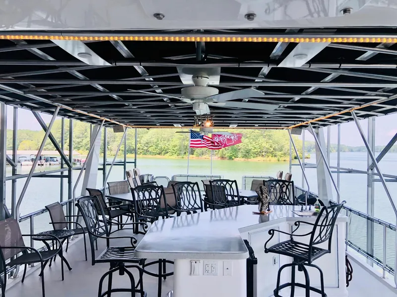 Slide: The Image of Upper deck of 2016 Thoroughbred 67x17 houseboat with bar seating and lake view. - 33