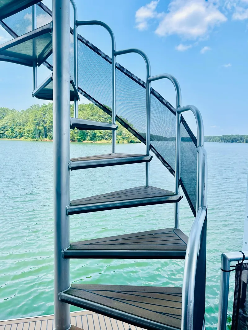 Slide: The Image of Spiral staircase on a Thoroughbred 67x17 houseboat, 2016 model, overlooking a serene lake. - 37