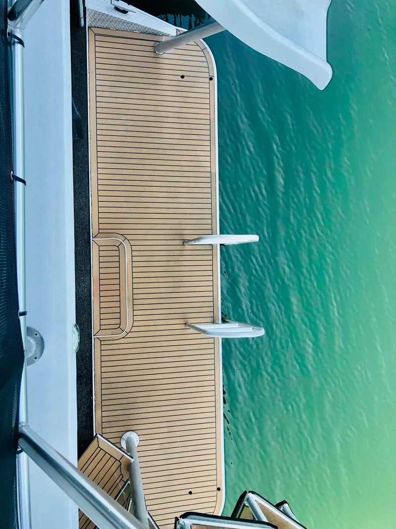 Slide: The Image of 2016 Thoroughbred 67x17 boat deck with swim ladder and slide over clear water. - 41