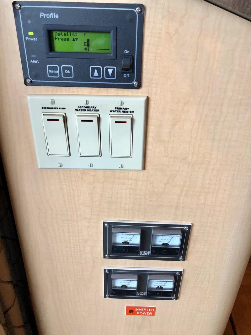 Slide: The Image of Control panel of a 2016 Thoroughbred 67x17 RV with switches and meters. - 49