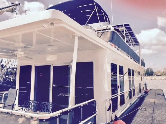 Slide: The Image of 2016 Thoroughbred 67x17 houseboat docked at marina under a partly cloudy sky. - 7