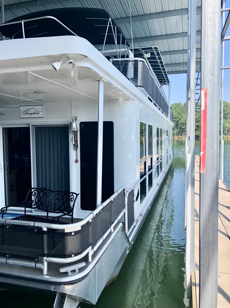 Slide: The Image of Modern 2016 Thoroughbred 67x17 houseboat docked under a covered marina. - 9