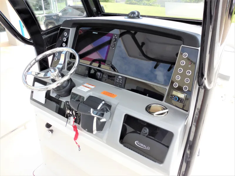 Slide: The Image of 2023 Robalo R250 boat dashboard with steering wheel and control panel. - 11
