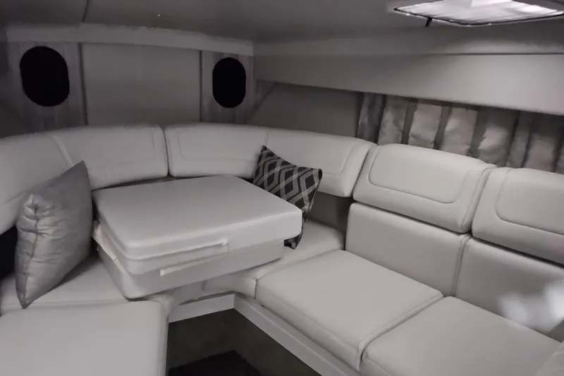 Slide: The Image of 2023 Formula 310 Sun Sport interior with plush white seating and decorative pillows. - 13