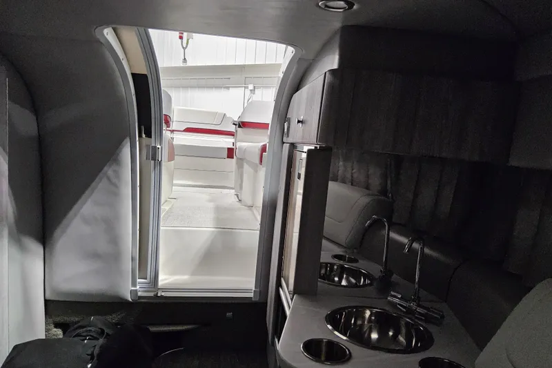 Slide: The Image of Interior view of 2023 Formula 310 Sun Sport boat, featuring a kitchenette and seating area. - 16
