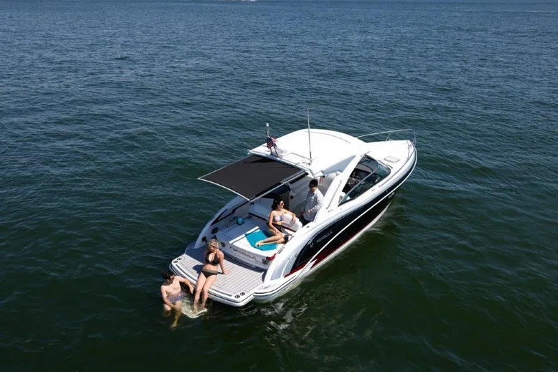 Slide: The Image of 2023 Formula 310 Sun Sport boat with people relaxing on deck and swimming in the water. - 7