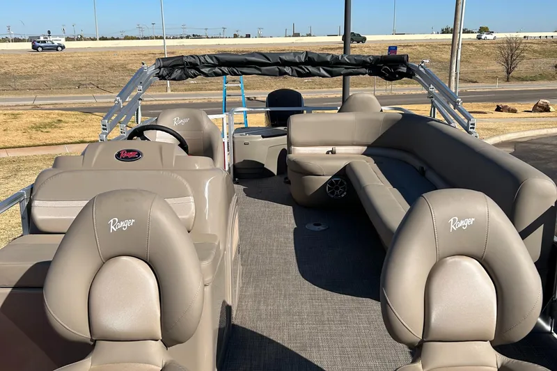 Slide: The Image of 2024 Ranger Reata 200F pontoon boat with beige seating and steering console. - 7