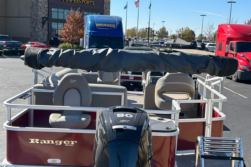 Slide: The Image of 2024 Ranger Reata 200F pontoon boat with Mercury 90 engine in a parking lot. - 8