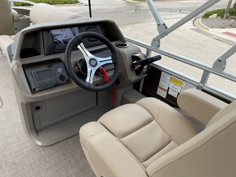Slide: The Image of 2024 Sun Tracker Sportfish 24 XP3 boat helm with beige captain's chair and steering wheel. - 5