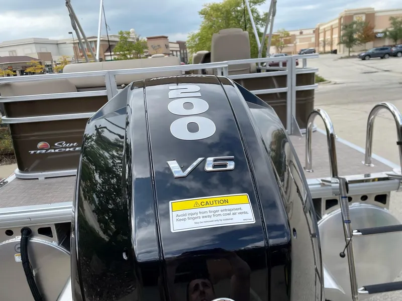 Slide: The Image of 2024 Sun Tracker Sportfish 24 XP3 with 200 HP V6 engine in a parking lot. - 9