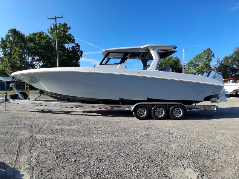 Slide: The Image of 2023 Fountain 38 SCX boat on trailer, parked outdoors under clear blue sky. - 10