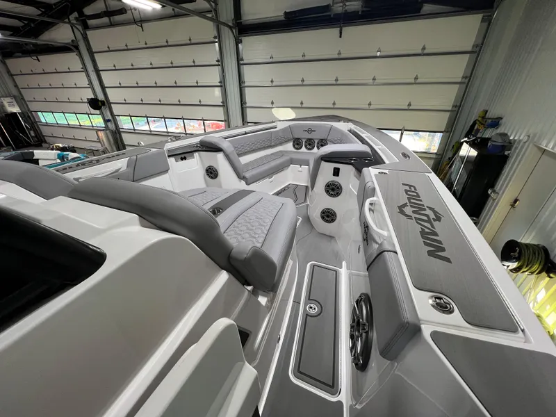 Slide: The Image of 2023 Fountain 38 SCX boat interior with gray seating and modern design in a garage. - 15