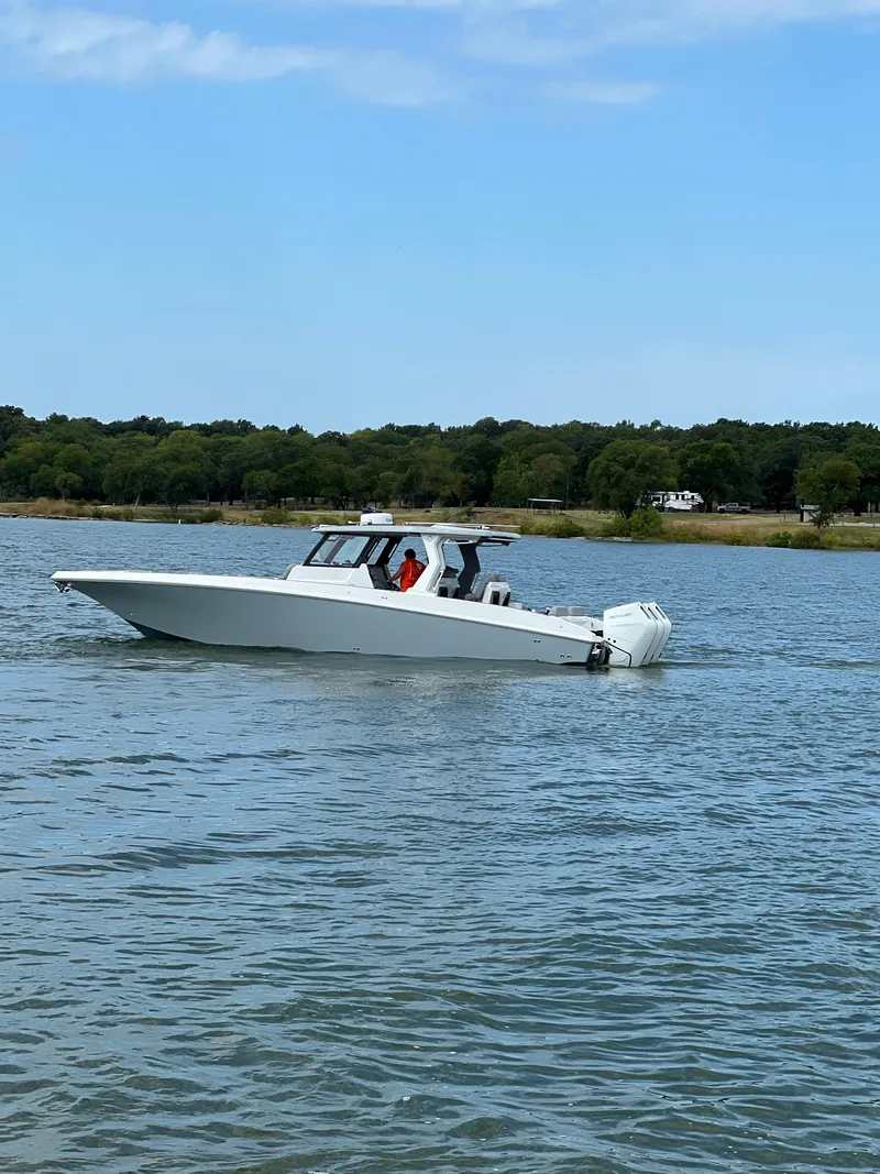 Slide: The Image of 2023 Fountain 38 SCX boat cruising on a calm lake. - 23