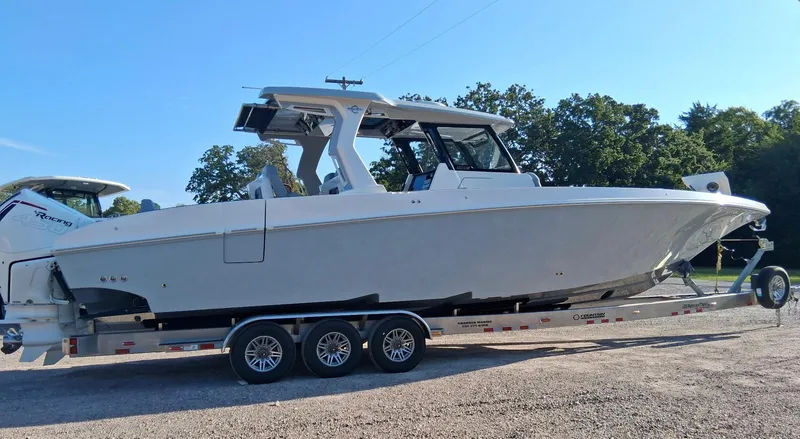 Slide: The Image of 2023 Fountain 38 SCX boat on trailer, parked outdoors under clear sky. - 34