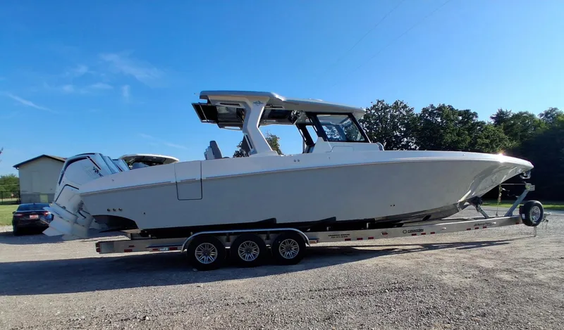 Slide: The Image of 2023 Fountain 38 SCX boat on trailer, parked outdoors under clear blue sky. - 35