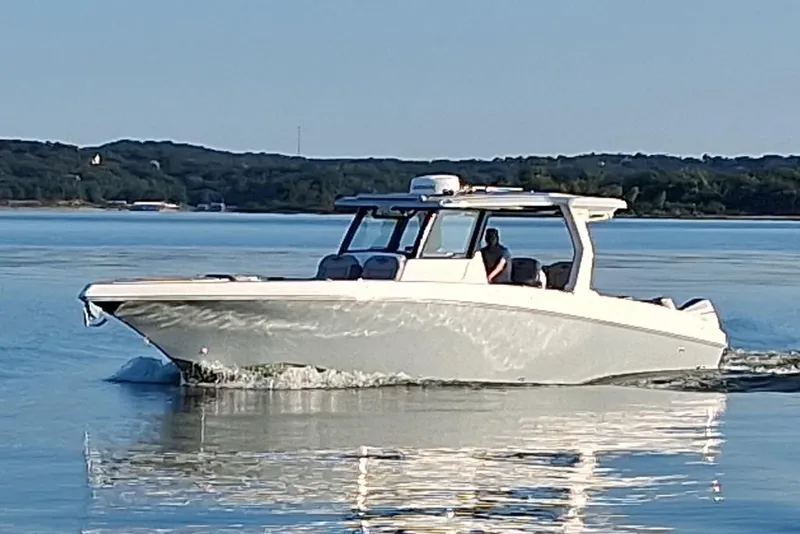 Slide: The Image of 2023 Fountain 38 SCX boat cruising on calm water with scenic background. - 39