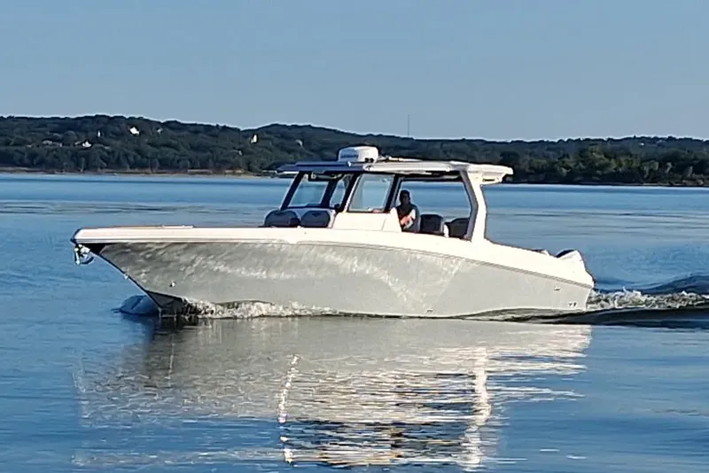 Slide: The Image of 2023 Fountain 38 SCX boat cruising on calm water with scenic background. - 41