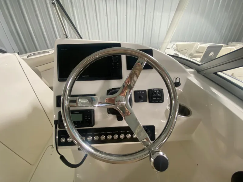 Slide: The Image of 2024 Key West 239 DFS boat dashboard with steering wheel and control panel. - 14