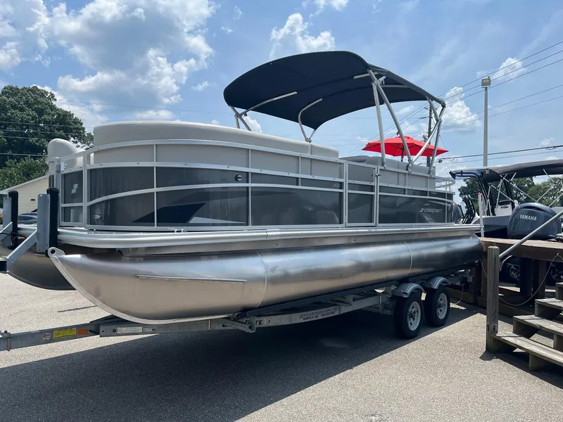 Slide: The Image of 2024 Starcraft LX22 F pontoon boat on trailer under sunny sky. - 3