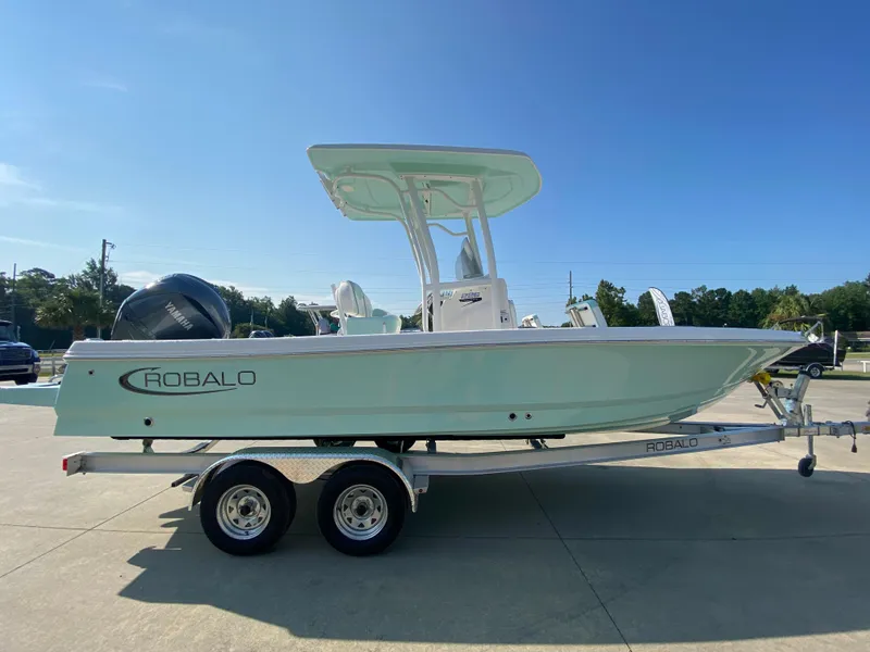 Slide: The Image of 2024 Robalo 226 Cayman boat on a trailer in a parking lot. - 1