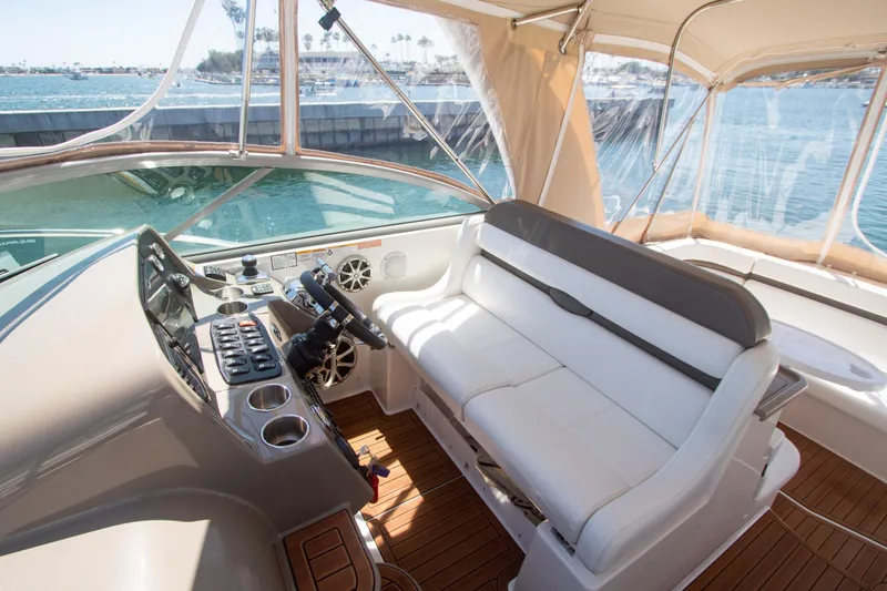 Slide: The Image of 2008 Rinker 400 Express Cruiser helm with white seating and wood flooring - 5