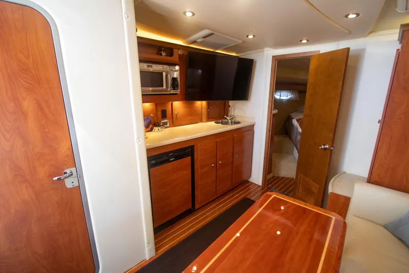 Slide: The Image of Interior of 2008 Rinker 400 Express Cruiser with kitchenette and TV. - 9