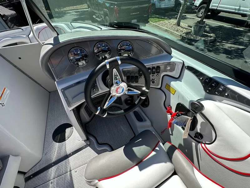 Slide: The Image of 2024 Sanger V237 S boat cockpit with steering wheel and dashboard controls. - 17