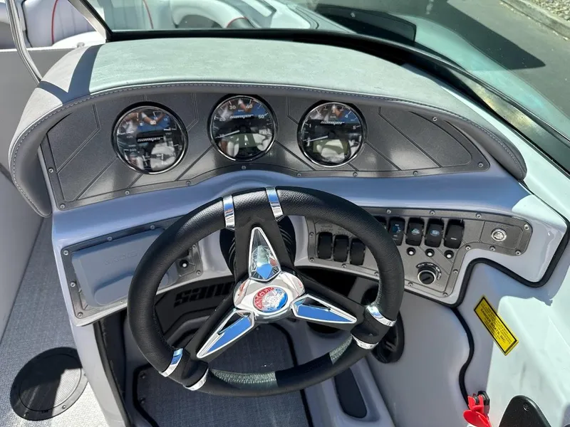 Slide: The Image of 2024 Sanger V237 S boat dashboard with steering wheel and gauges. - 18