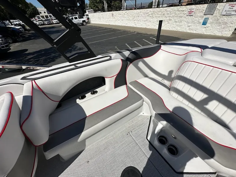 Slide: The Image of 2024 Sanger V237 S boat interior with white and gray seating, red trim, and cup holders. - 23