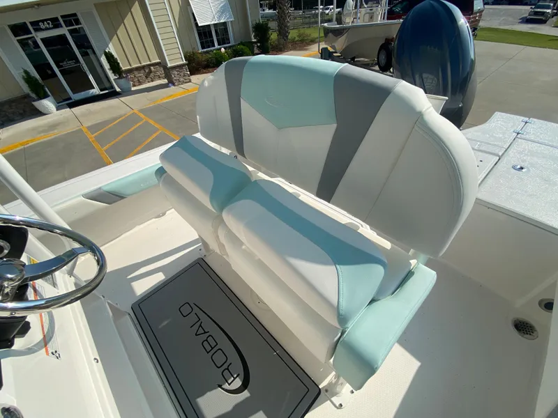 Slide: The Image of 2024 Robalo 226 Cayman boat interior with dual-tone seating and steering wheel. - 12