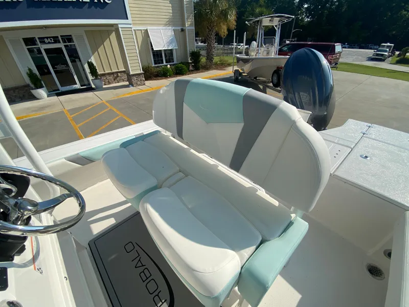 Slide: The Image of 2024 Robalo 226 Cayman boat interior with cushioned seating and steering wheel. - 13