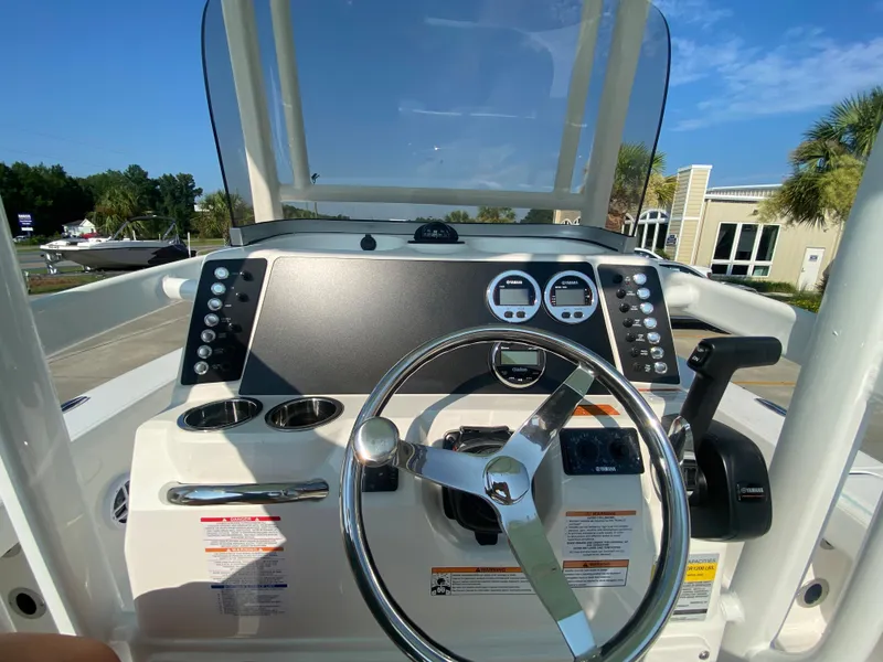 Slide: The Image of 2024 Robalo 226 Cayman boat dashboard with steering wheel and controls. - 14