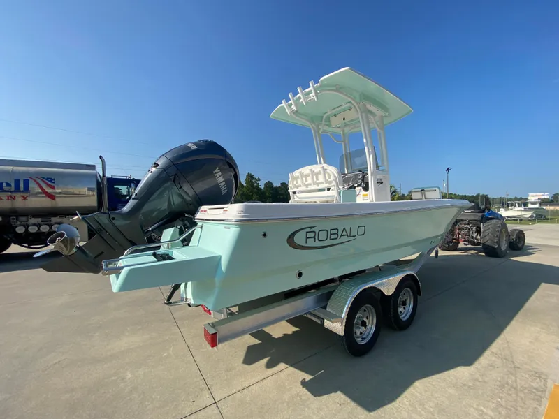 Slide: The Image of 2024 Robalo 226 Cayman boat on a trailer, rear view, outdoor setting. - 2