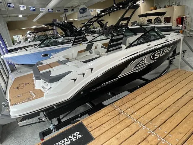 The Image of 2025 Chaparral 23 Surf boat displayed in showroom, featuring sleek design and modern features. - 0
