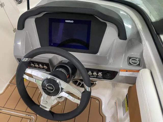 Slide: The Image of 2025 Chaparral 23 Surf boat dashboard with steering wheel and digital display. - 11