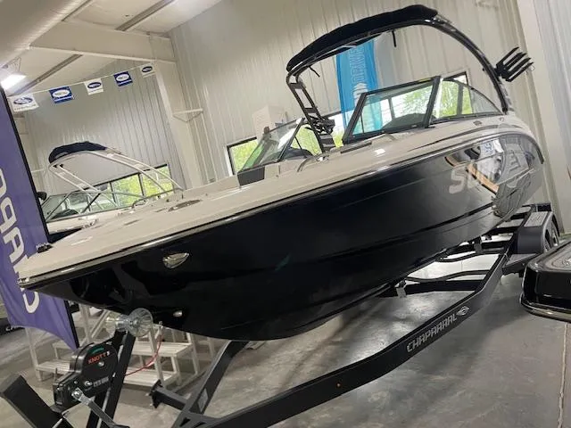 Slide: The Image of 2025 Chaparral 23 Surf boat displayed in showroom on trailer. - 2