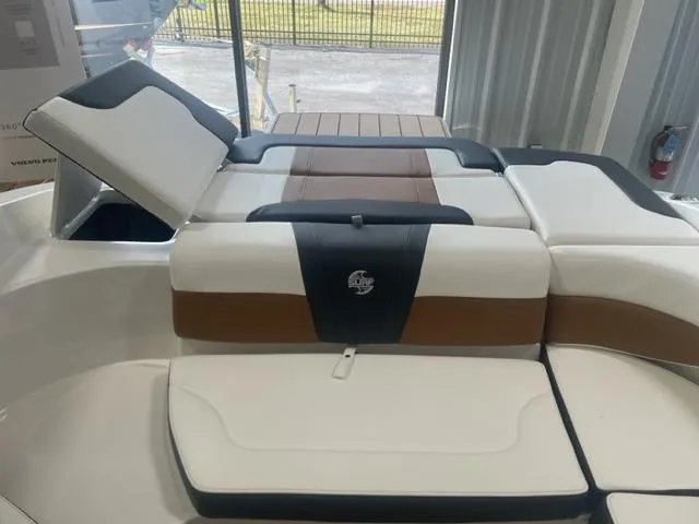 Slide: The Image of 2023 Chaparral 23 Surf boat interior with cushioned seating and storage compartments. - 6