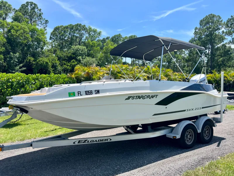 Slide: The Image of 2021 Starcraft 211 SVX boat on EZ Loader trailer, parked outdoors. - 1