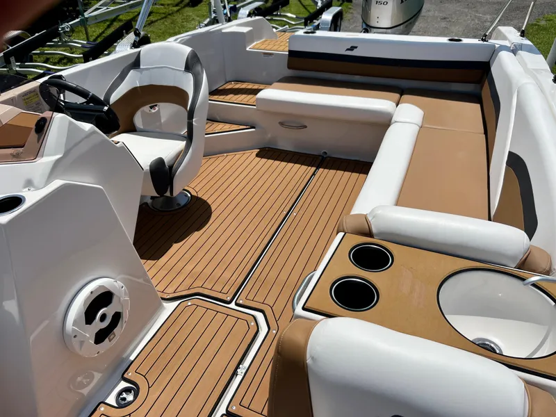 Slide: The Image of 2021 Starcraft 211 SVX boat interior with tan and white seating and wood-like flooring. - 12