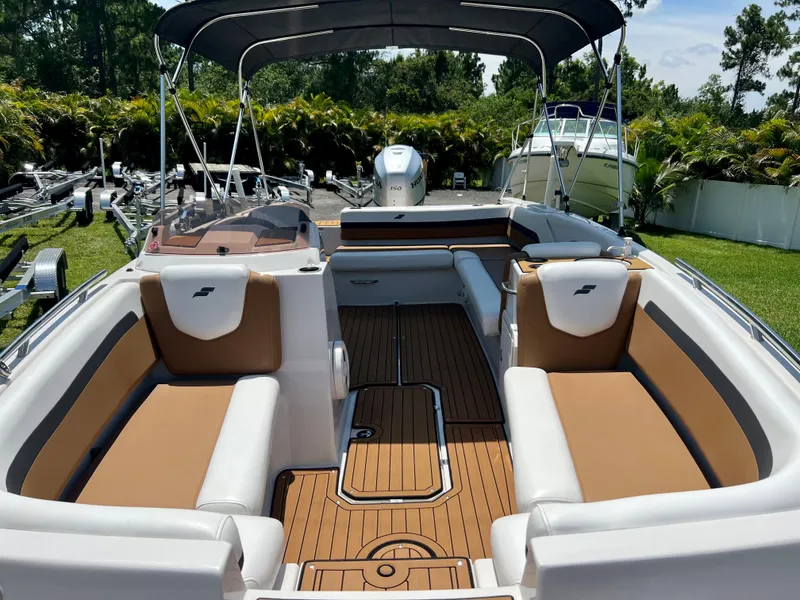 Slide: The Image of 2021 Starcraft 211 SVX boat interior with tan and white seating, teak flooring, and canopy. - 13