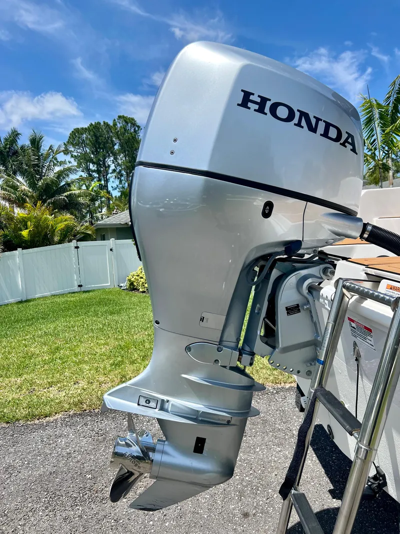 Slide: The Image of 2021 Starcraft 211 SVX with Honda outboard motor in a sunny backyard. - 17