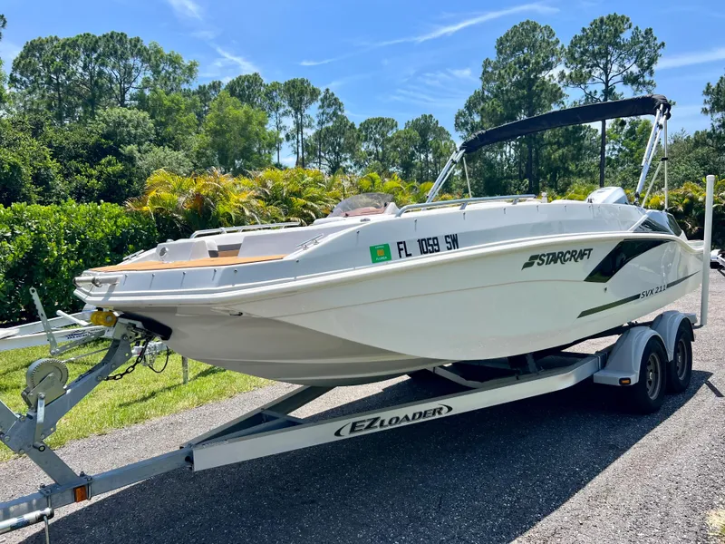 Slide: The Image of 2021 Starcraft 211 SVX boat on EZ Loader trailer in a scenic outdoor setting. - 3