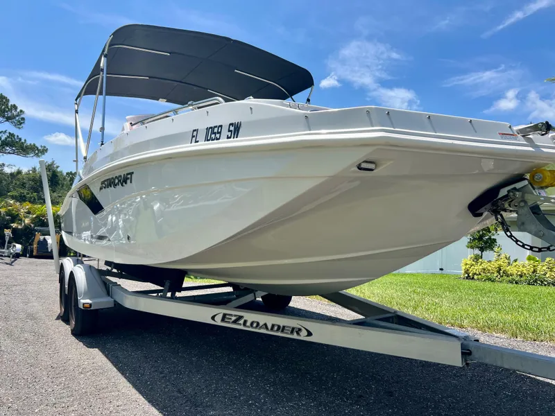 Slide: The Image of 2021 Starcraft 211 SVX boat on EZ Loader trailer with canopy, parked outdoors. - 4