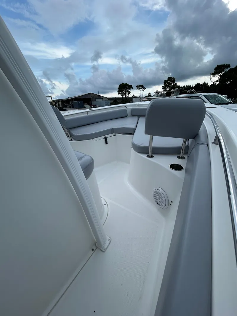 Slide: The Image of 2019 Sea Hunt 225 Ultra boat interior with seating, under a cloudy sky. - 10