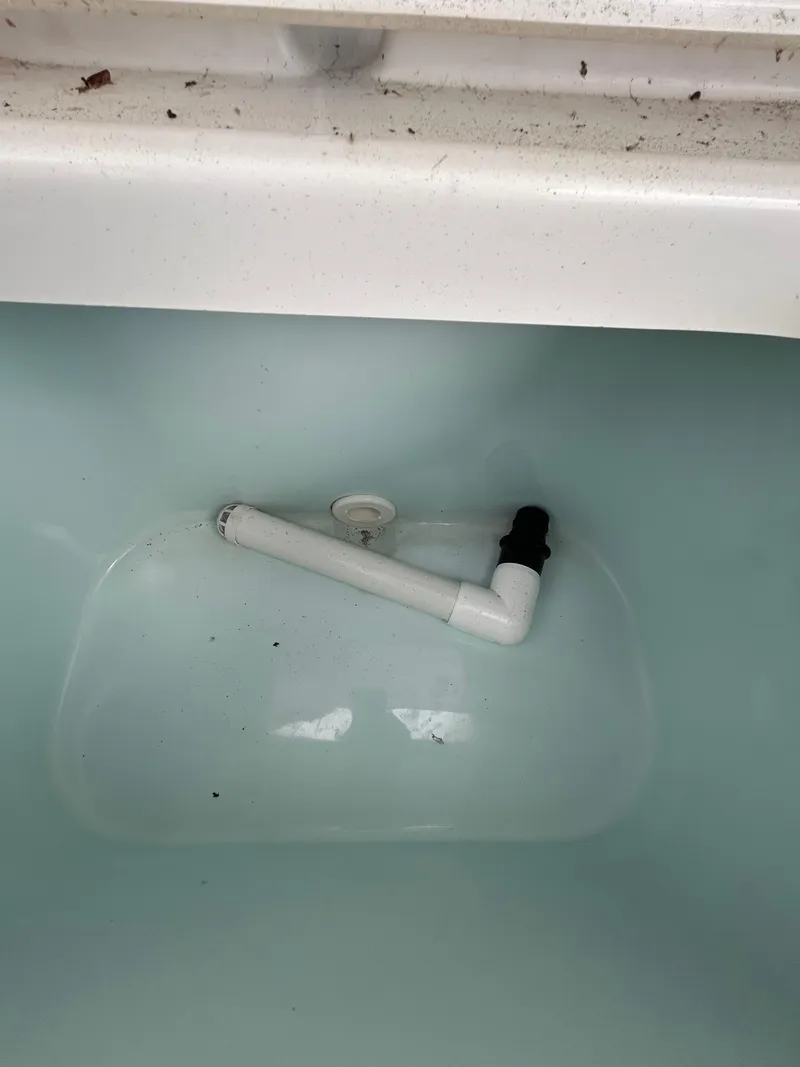 Slide: The Image of Livewell interior of a 2019 Sea Hunt 225 Ultra boat, featuring a drainage pipe. - 14