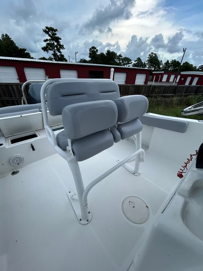 Slide: The Image of 2019 Sea Hunt 225 Ultra boat with cushioned seating and storage units. - 19