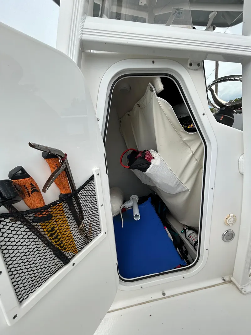 Slide: The Image of Storage compartment of a 2019 Sea Hunt 225 Ultra boat with various equipment. - 22